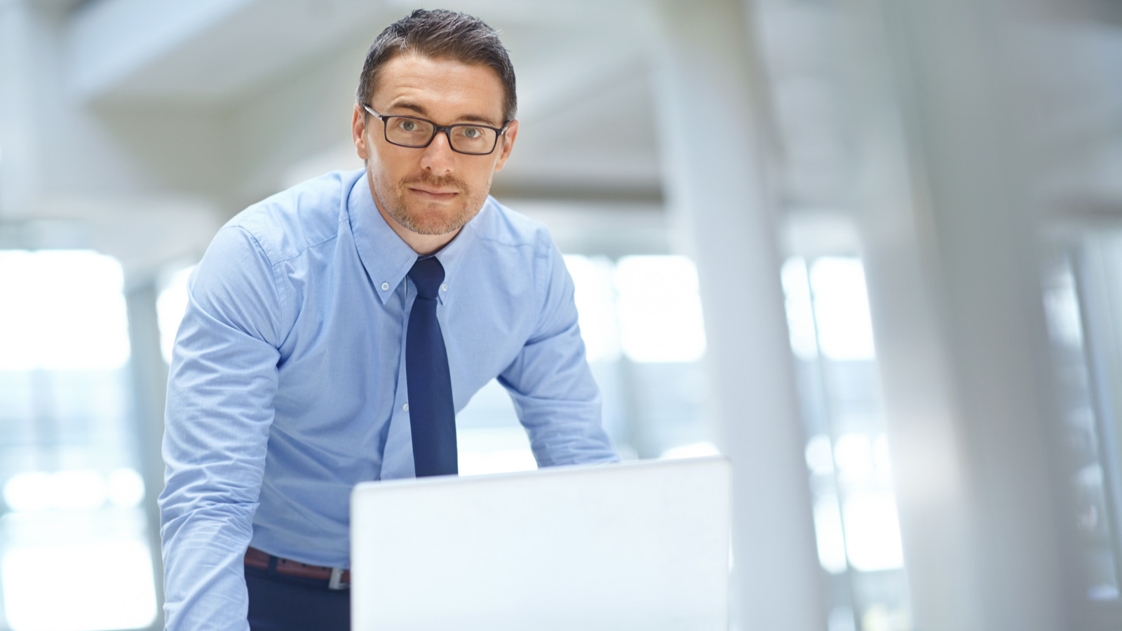executivo com um computador, olhando para frente