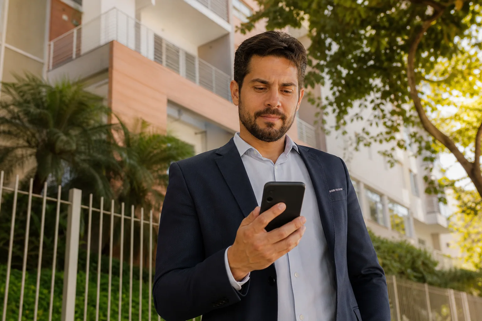 Corretor imobiliário brasileiro enviando mensagem personalizada no celular na rua